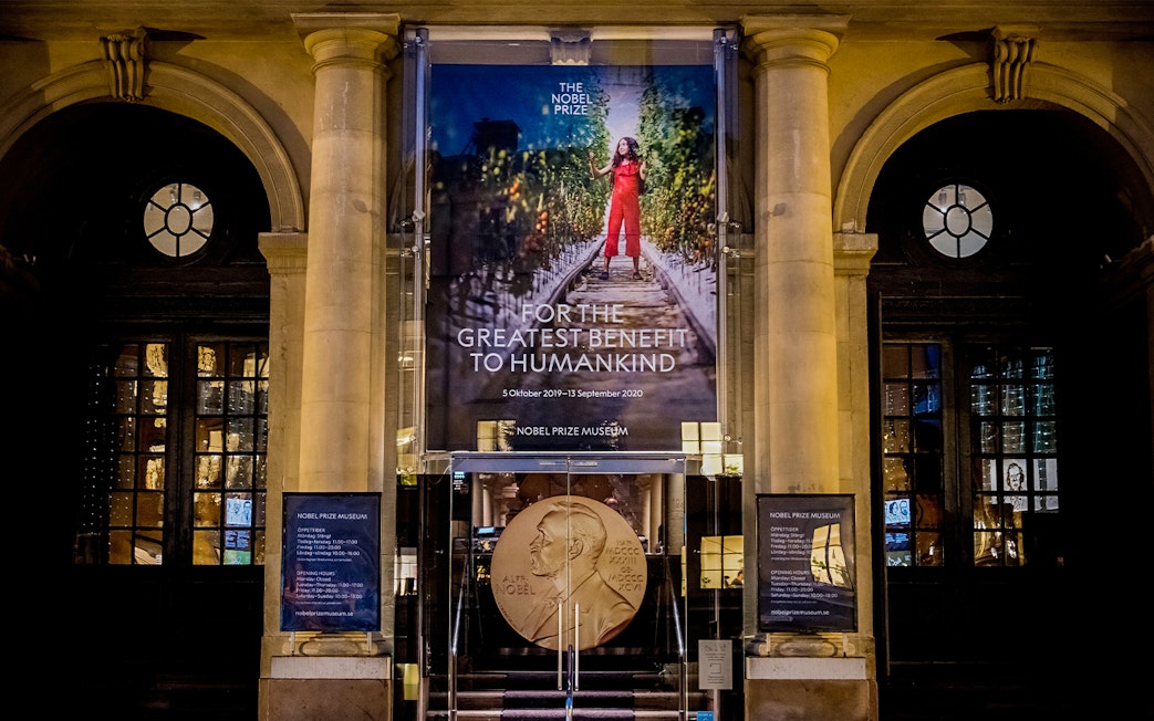 Nobel Prize Museum entrance in Stockholm, featuring a large banner and Nobel medal display.
