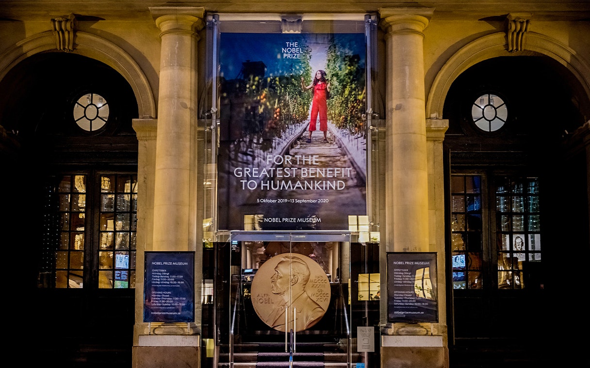 Nobel Prize Museum entrance in Stockholm, featuring a large banner and Nobel medal display.