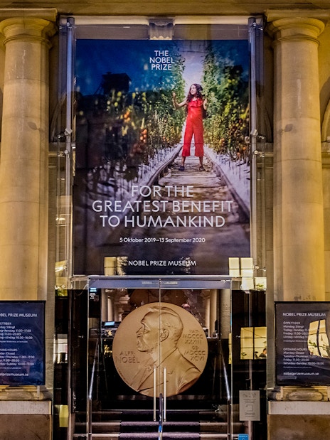 Nobel Prize Museum entrance in Stockholm, featuring a large banner and Nobel medal display.