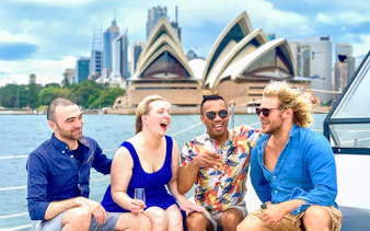 Group enjoying Harbour Highlights Catamaran Cruise with Sydney Opera House in background.