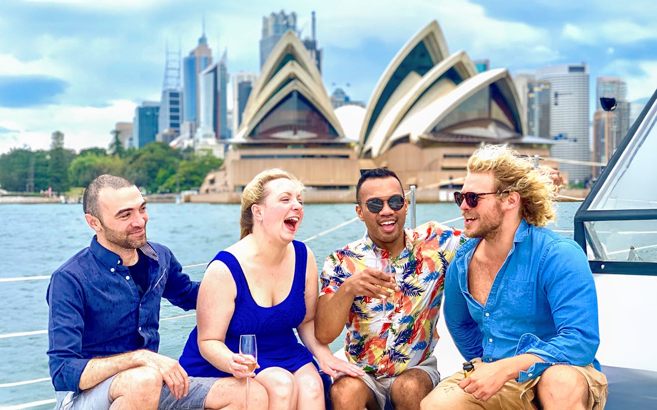 Group enjoying Harbour Highlights Catamaran Cruise with Sydney Opera House in background.