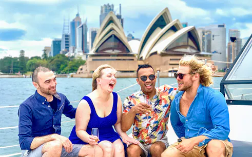 Group enjoying Harbour Highlights Catamaran Cruise with Sydney Opera House in background.