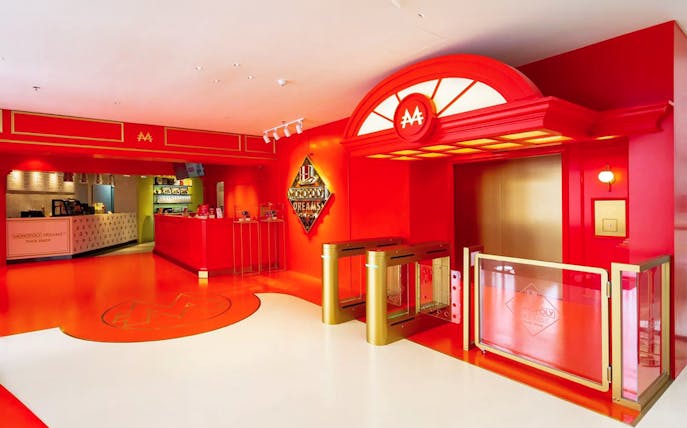 Entrance to MONOPOLY DREAMS™️ Hong Kong with ticket counter and turnstiles.