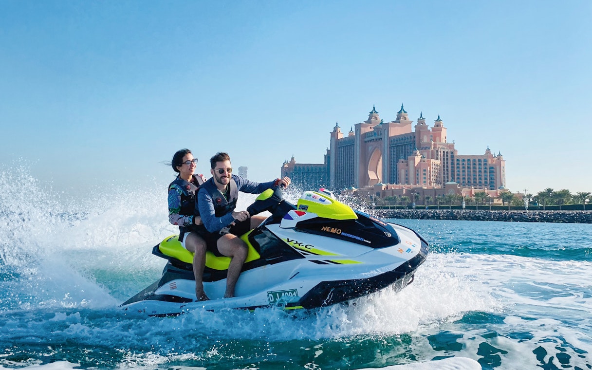 Couple jet skiing near Atlantis, The Palm in Dubai.