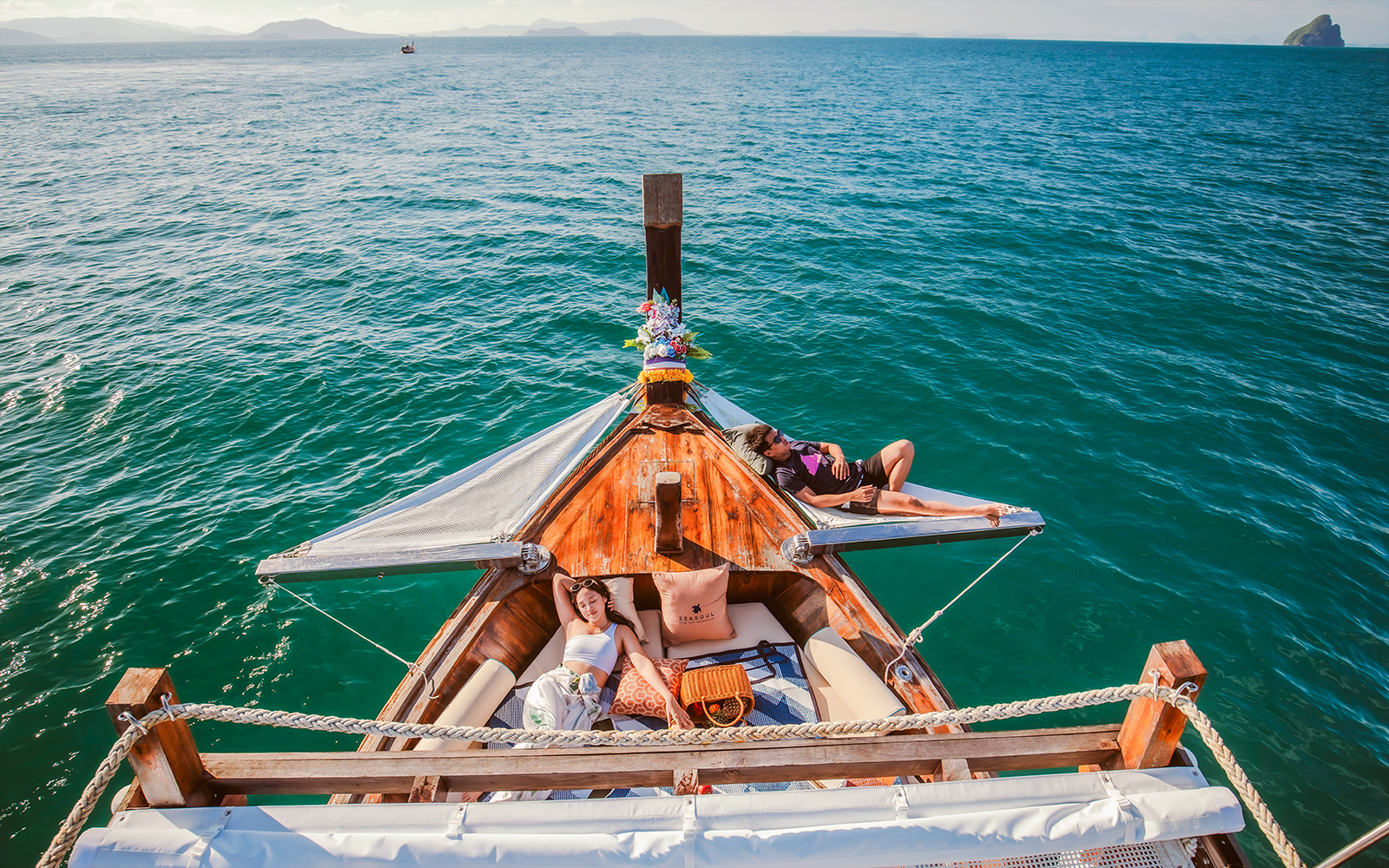 Luxury longtail boat cruise at sunset in Krabi with people relaxing.