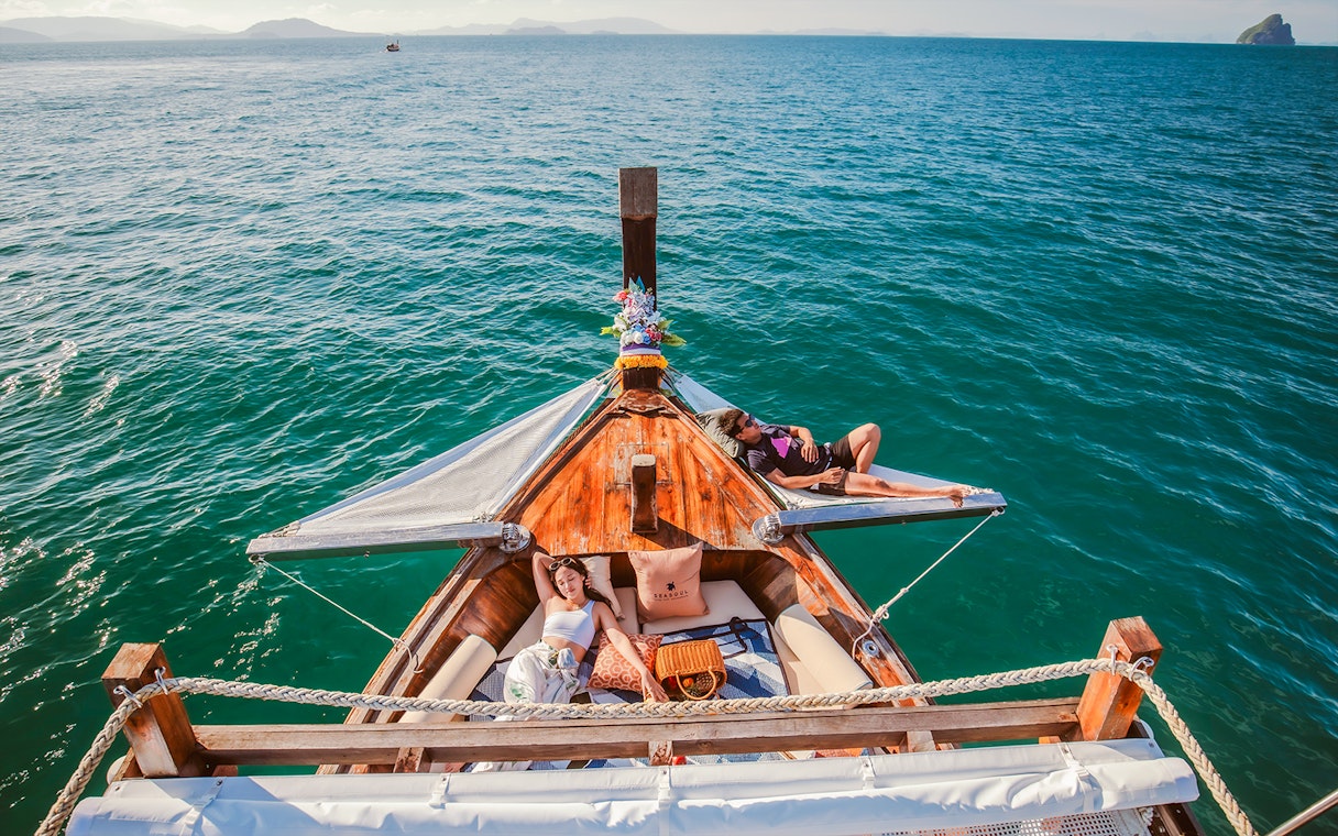 Luxury longtail boat cruise at sunset in Krabi with people relaxing.