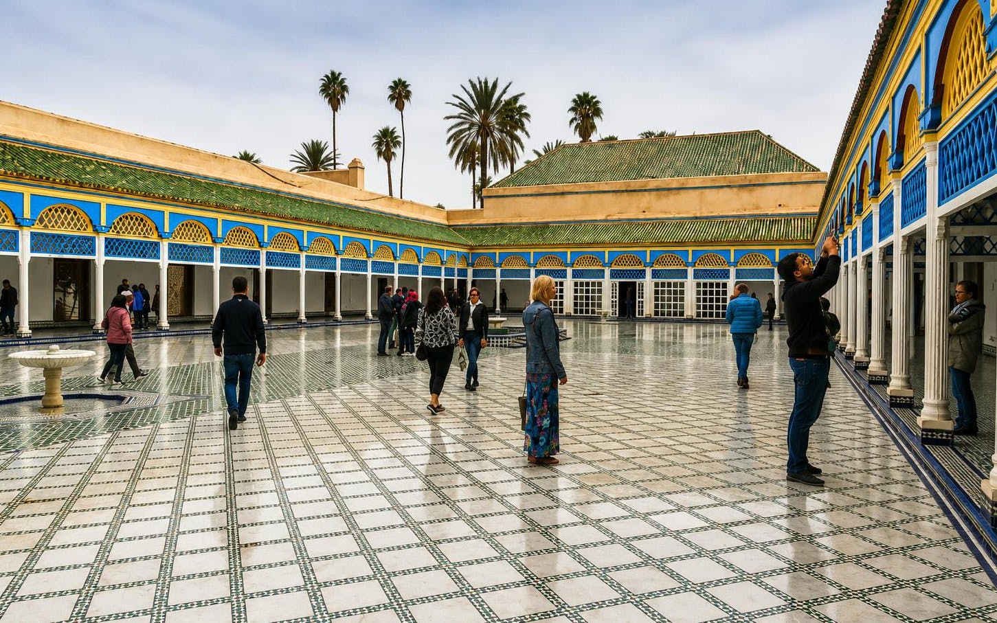 Visitors exploring the courtyard of Bahia Palace in Marrakech's Medina.