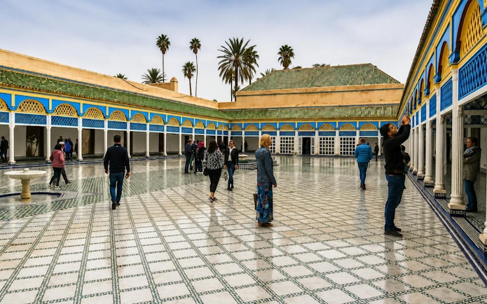 Visitors exploring the courtyard of Bahia Palace in Marrakech's Medina.