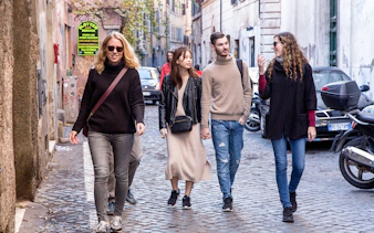 Friends walking on a cobblestone street in Rome, Italy.