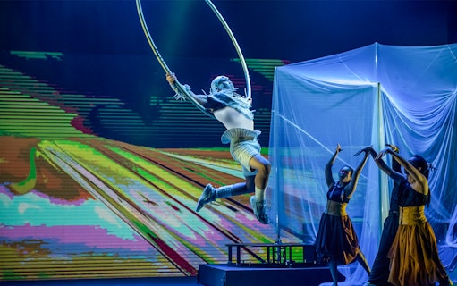 Performer in mid-air hoop act at Earth Symphony, Circus fest.
