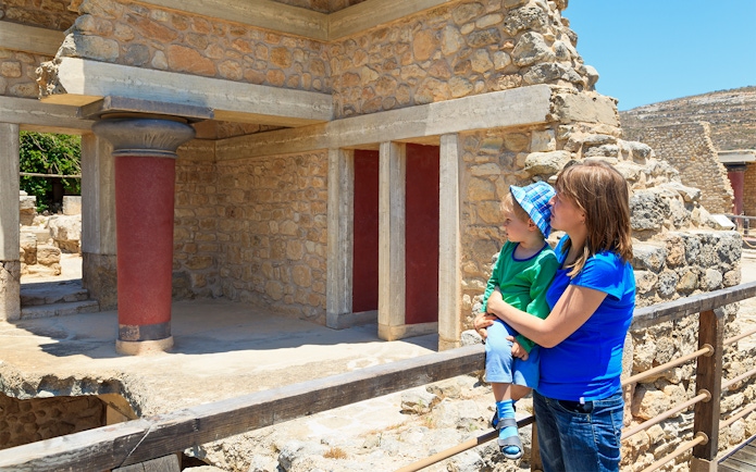 Family exploring Knossos Palace ruins in Crete, Greece.