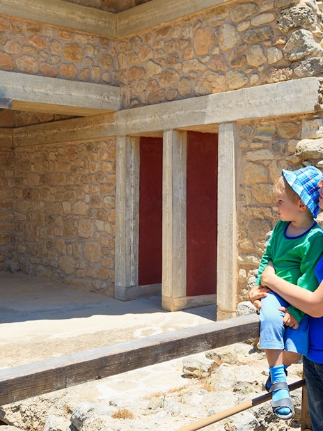 Family exploring Knossos Palace ruins in Crete, Greece.