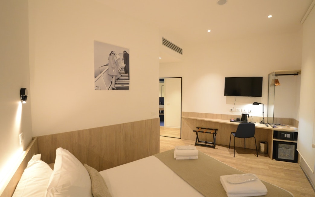 Modern lounge room with bed, desk, and TV at Plaza Premium Lounge, Terminal 1, Fiumicino Airport, Rome.