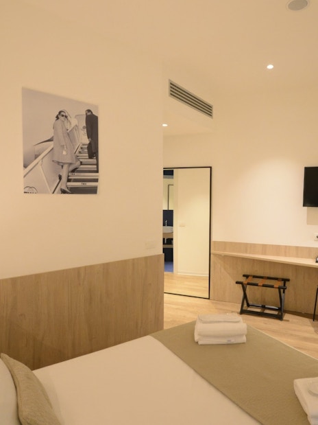 Modern lounge room with bed, desk, and TV at Plaza Premium Lounge, Terminal 1, Fiumicino Airport, Rome.