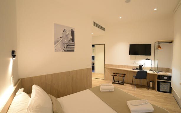 Modern lounge room with bed, desk, and TV at Plaza Premium Lounge, Terminal 1, Fiumicino Airport, Rome.