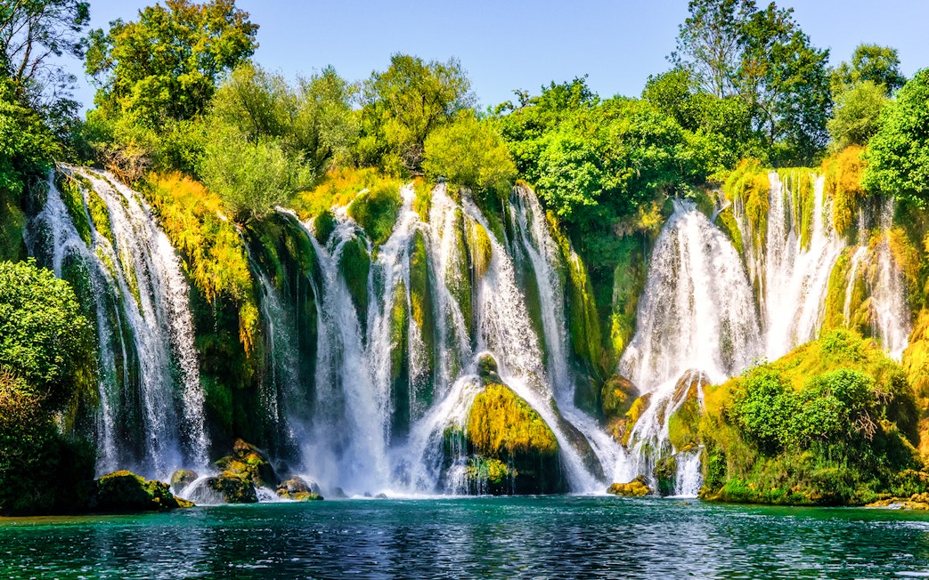 Kravica Waterfall cascading over lush greenery on Trebizat River, Bosnia.