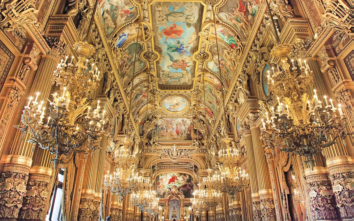 Garnier Opera's ornate ceiling and chandeliers during Arsene Lupin Immersive Game in Paris.