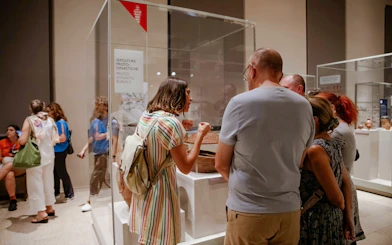 Visitors observing Proto-Dynastic burials exhibit at the Egyptian Museum in Turin.