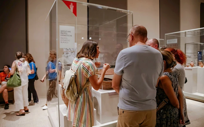 Visitors observing Proto-Dynastic burials exhibit at the Egyptian Museum in Turin.