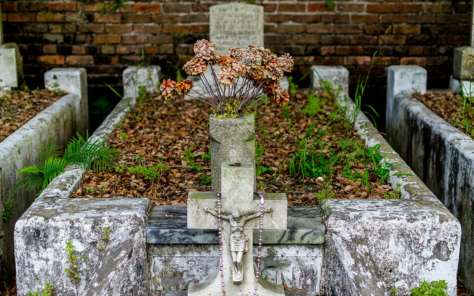 Crucifix and flowers on a tomb in Lafayette Cemetery, New Orleans.