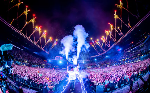 Crowd enjoying UNTOLD Music Festival Dubai with fireworks and stage effects.