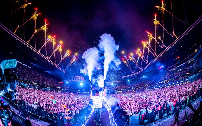 Crowd enjoying UNTOLD Music Festival Dubai with fireworks and stage effects.