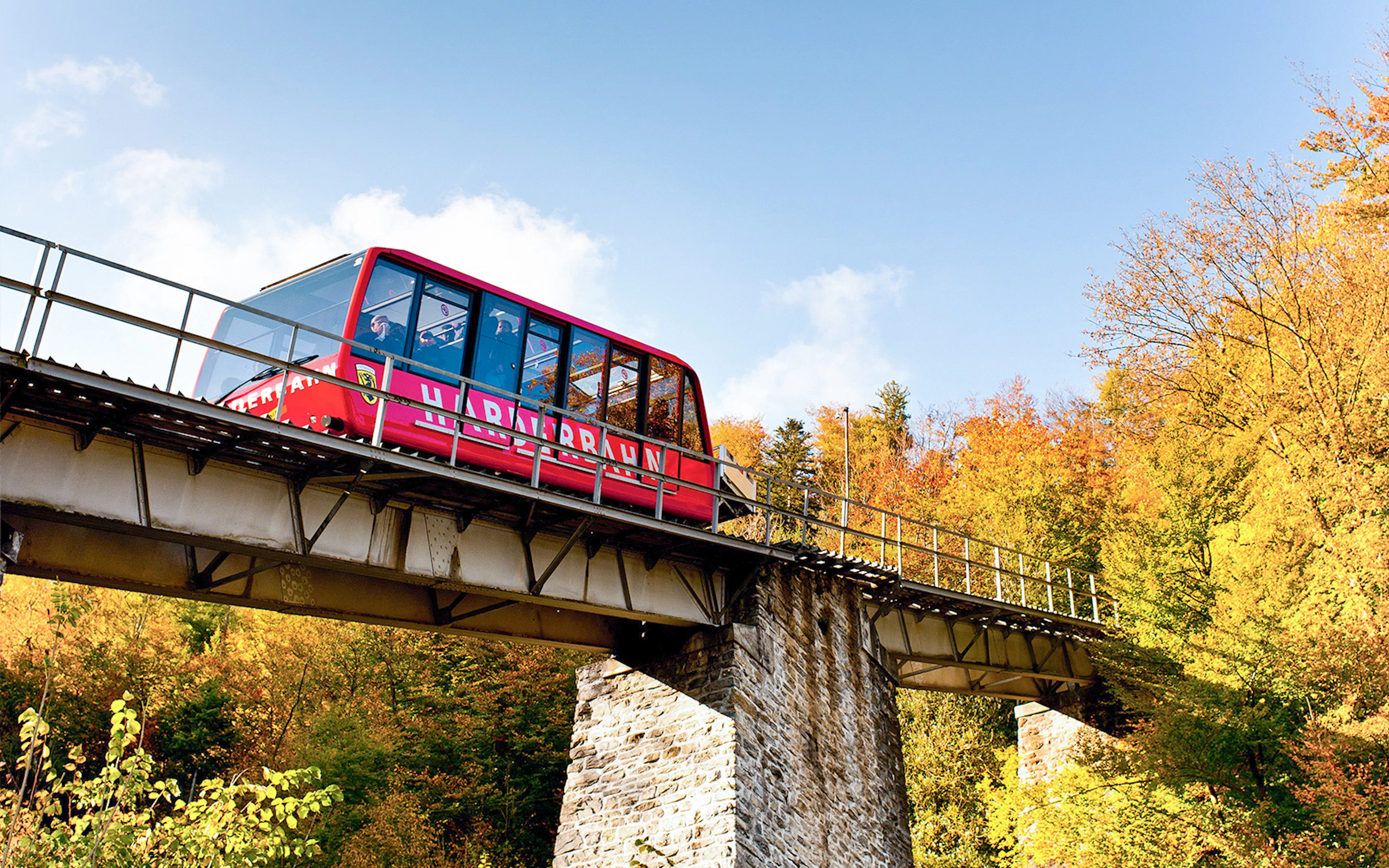 Harder Kulm funicular ascending through autumn trees in Interlaken.