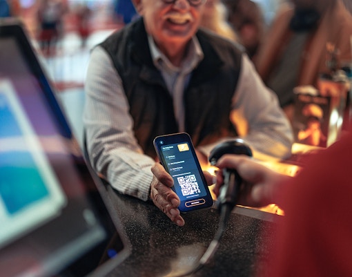 Person scanning QR code at a tourist attraction entrance in Paris, France.