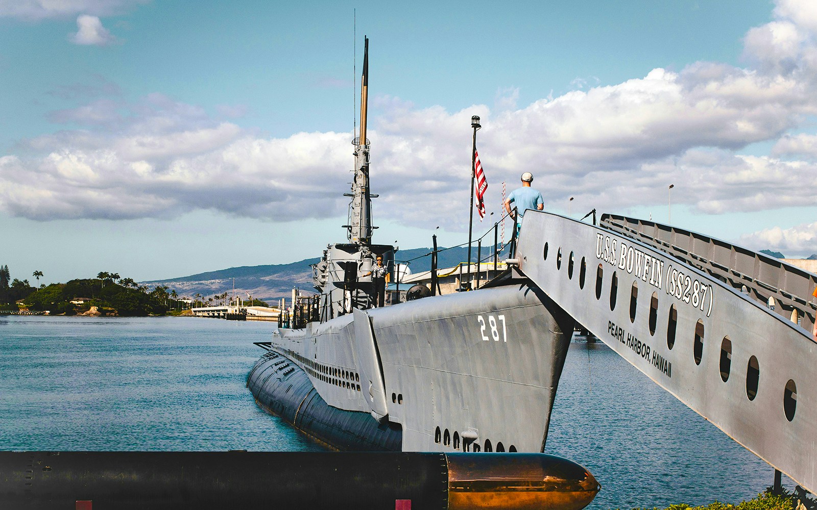 USS Bowfin Submarine docked at Pearl Harbor, Hawaii, with visitors on deck.