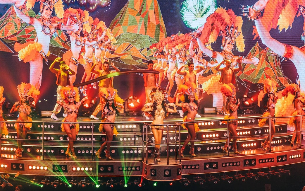 Samba dancers performing at Coco Bongo Show & Disco with vibrant costumes and stage lights.