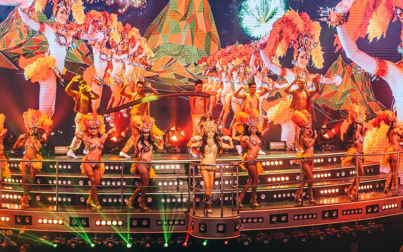 Samba dancers performing at Coco Bongo Show & Disco with vibrant costumes and stage lights.