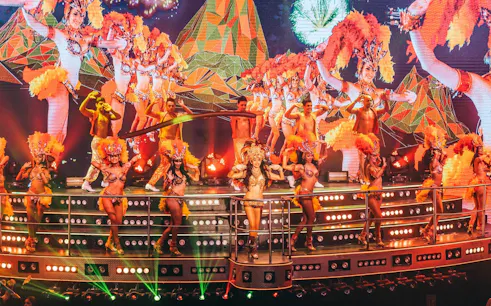 Samba dancers performing at Coco Bongo Show & Disco with vibrant costumes and stage lights.