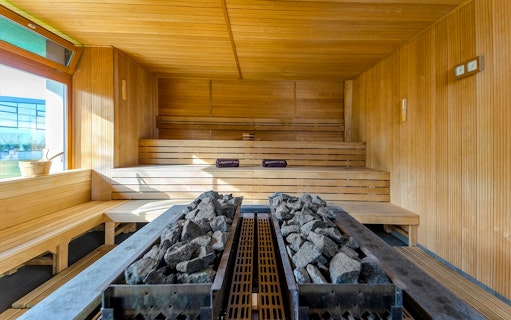 Sauna room with wooden benches and hot stones at Paskal Thermal Bath, Budapest.