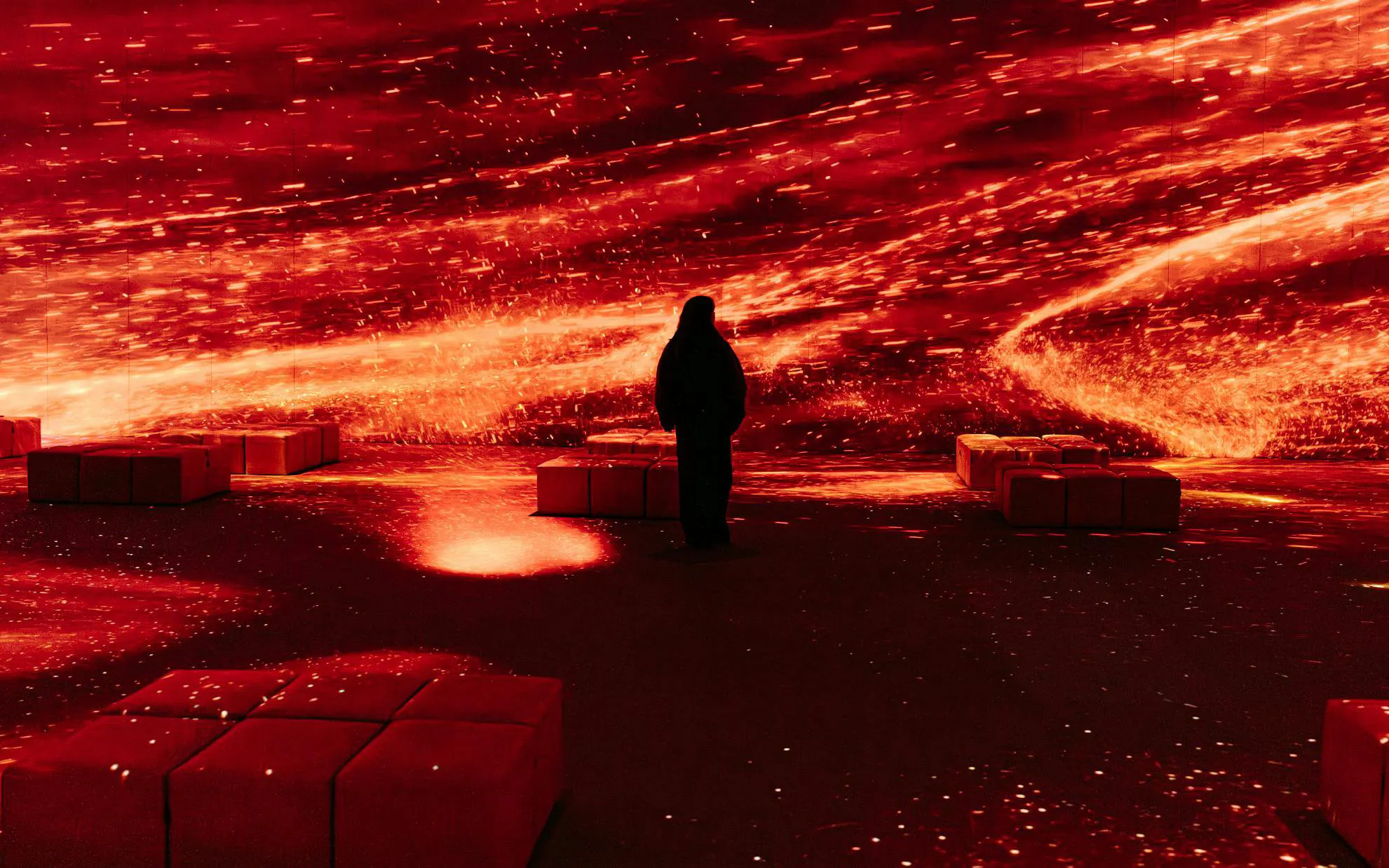 Person experiencing immersive Pompeia exhibit at IDEAL Barcelona with vibrant red visuals.