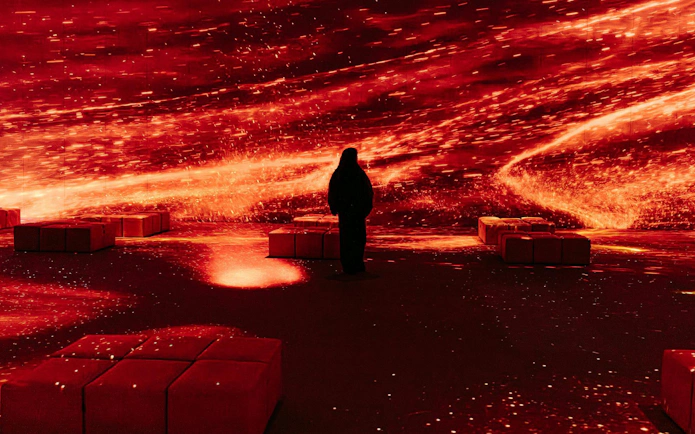 Person experiencing immersive Pompeia exhibit at IDEAL Barcelona with vibrant red visuals.