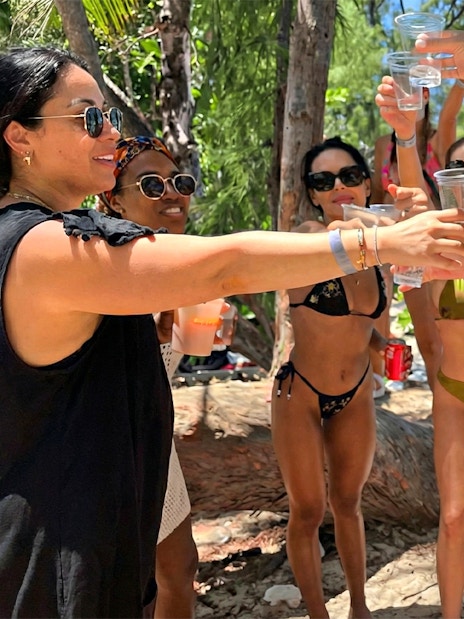 Group enjoying drinks on a beach during Mansa Bay private island day trip.