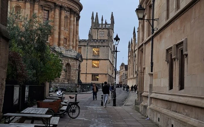 Oxford street view with Radcliffe Camera and tourists exploring.