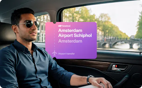 Man in car during Amsterdam airport transfer with canal view.
