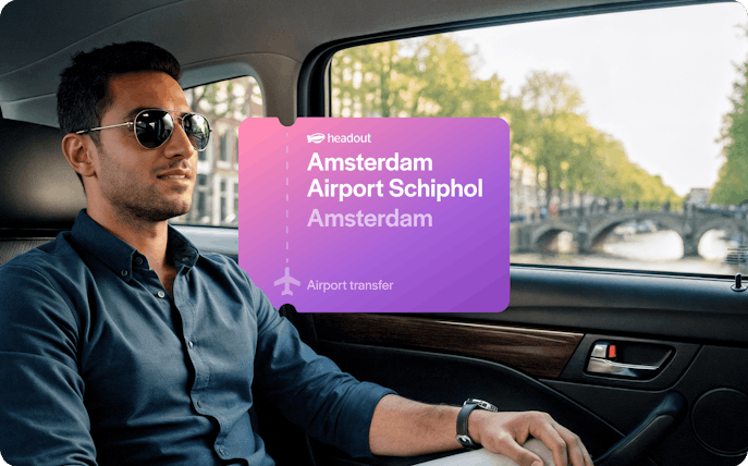 Man in car during Amsterdam airport transfer with canal view.