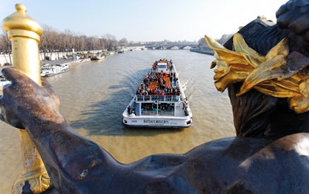 Bateaux Mouches boat cruising on the Seine River in Paris with passengers enjoying live music.