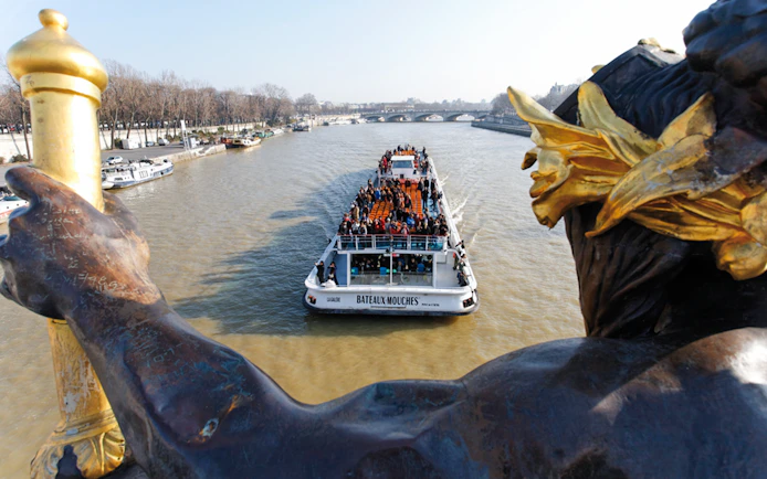Bateaux Mouches boat cruising on the Seine River in Paris with passengers enjoying live music.