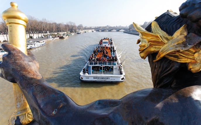Bateaux Mouches boat cruising on the Seine River in Paris with passengers enjoying live music.