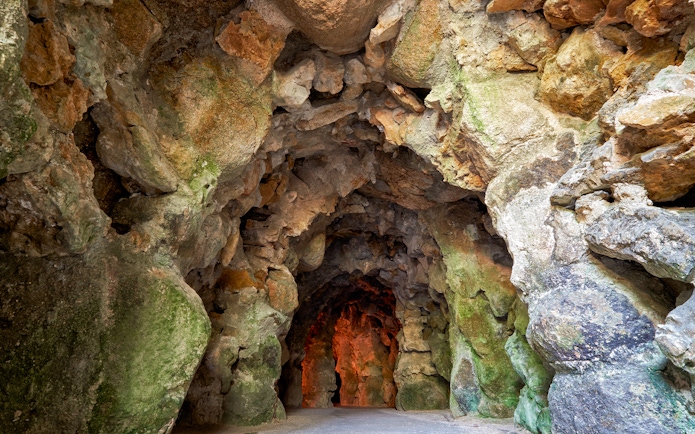 Cave interior with rocky walls at Quinta da Regaleira gardens in Lisbon.