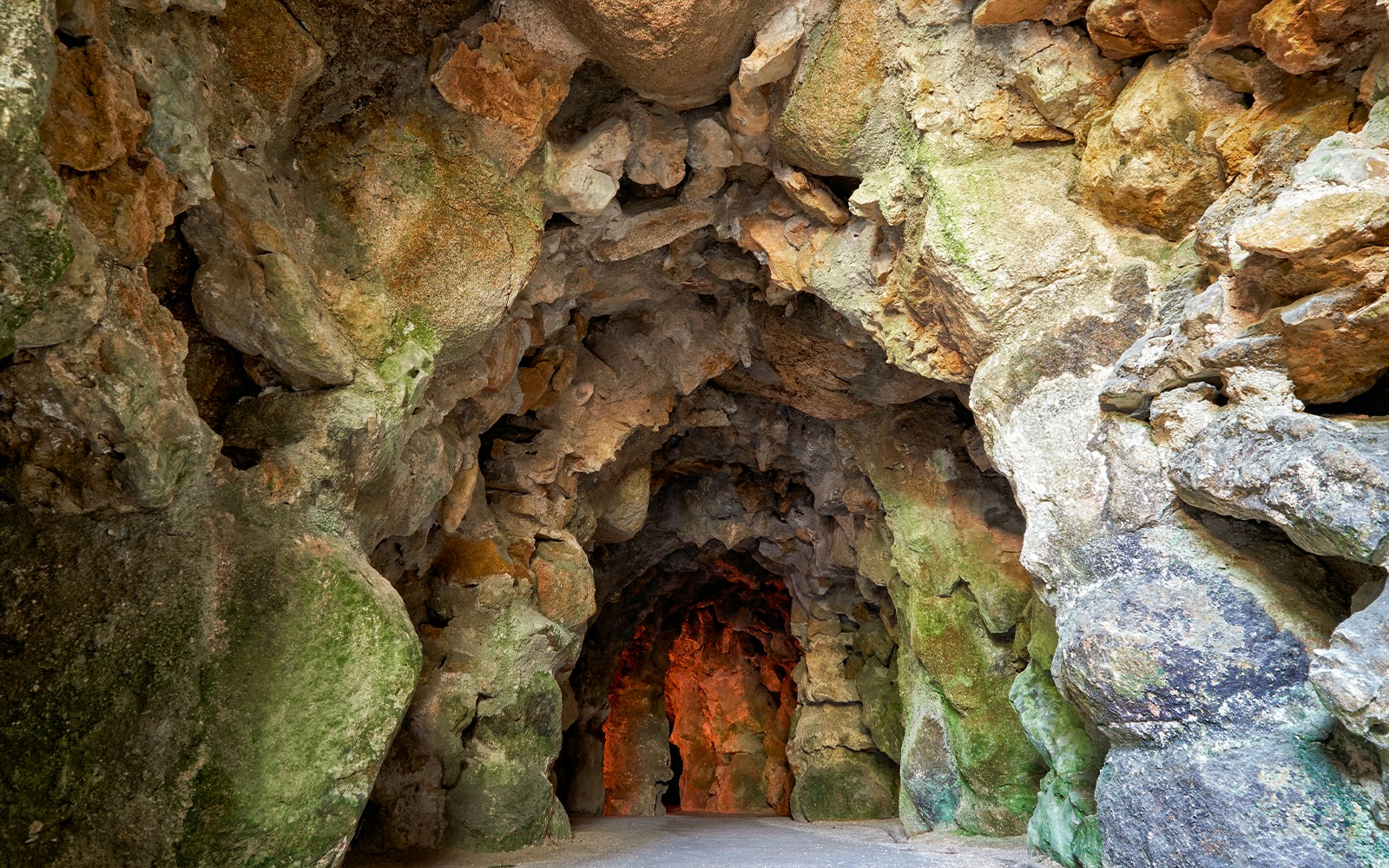 Quinta da Regaleira cave entrance surrounded by lush gardens in Lisbon.
