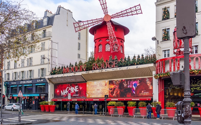 Red windmill of Moulin Rouge in Montmartre, Paris, during Montmartrain ride.