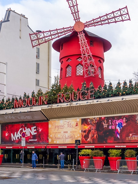 Red windmill of Moulin Rouge in Montmartre, Paris, during Montmartrain ride.