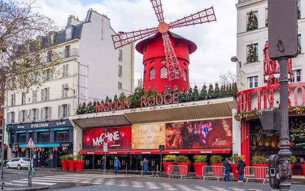 Red windmill of Moulin Rouge in Montmartre, Paris, during Montmartrain ride.