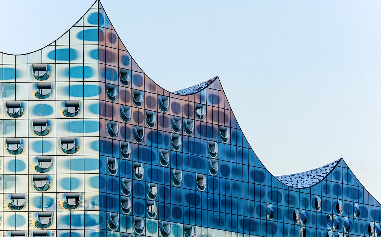 Elbphilharmonie's glass facade with wave-like roof design in Hamburg.