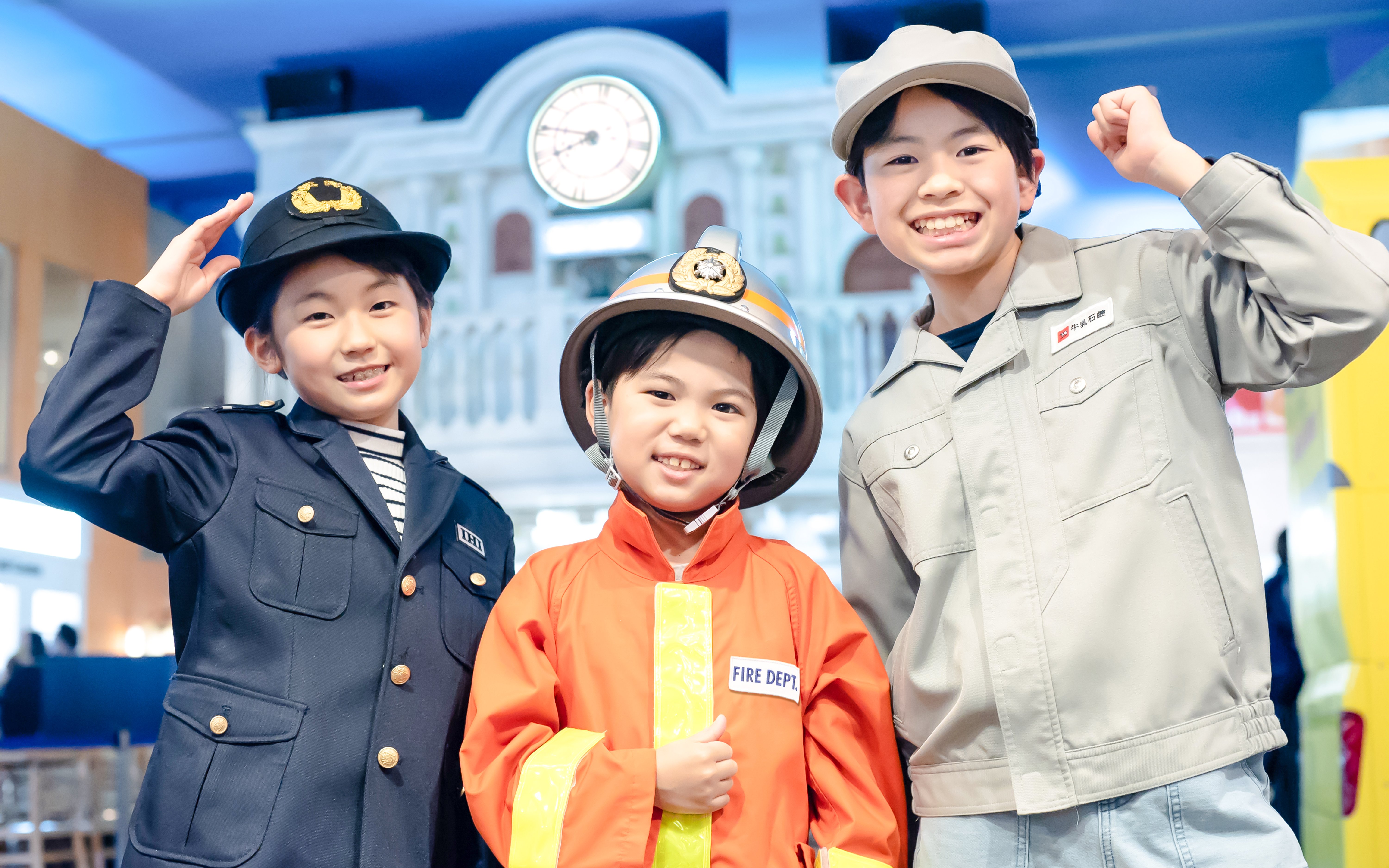 Children in firefighter and worker uniforms at KidZania Tokyo.