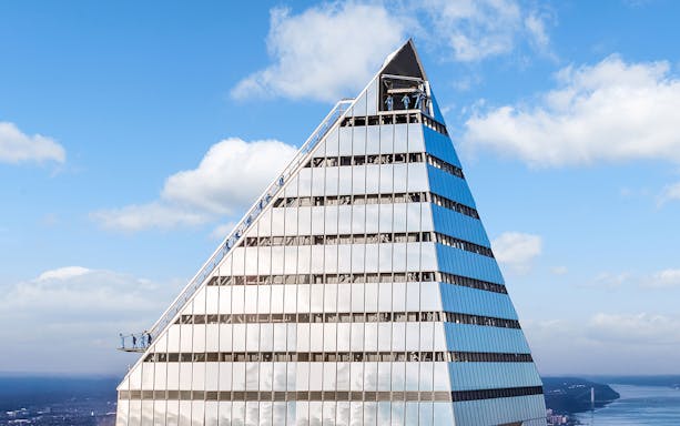 Climbers ascending the edge of a skyscraper during a City Climb Experience.